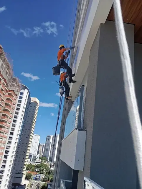 Profissional da RefazUrb em rapel restaurando fachada de prédio em São Paulo